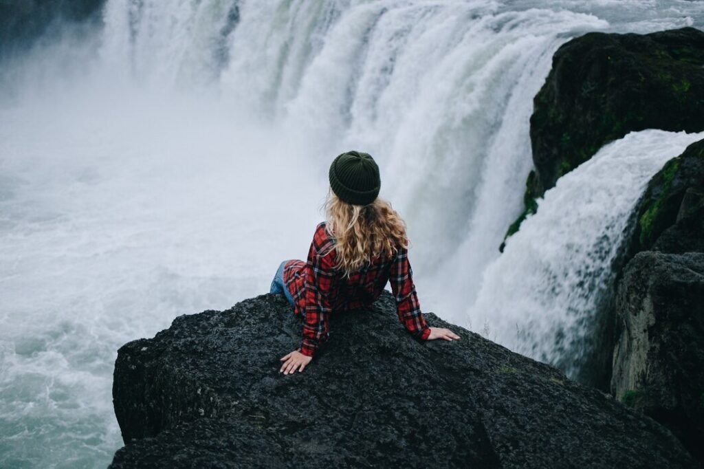 woman-sit-edge-cliff-waterfall_346278-89